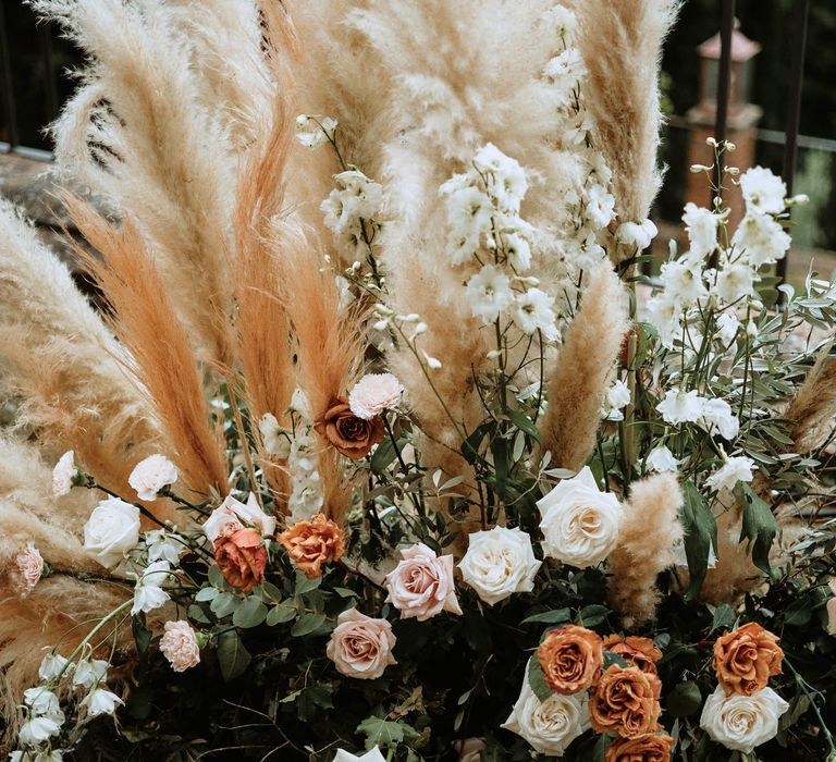 Peach and beige pampas grass decor with white carbonillo and pink, orange and white roses