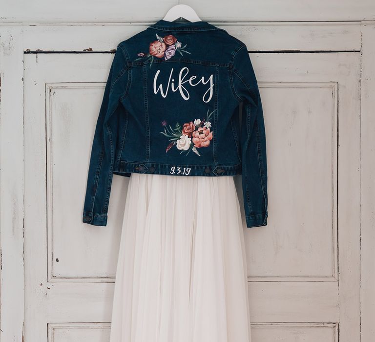 Deep blue bridal denim jacket with handpainted flowers with the bride's new last name 