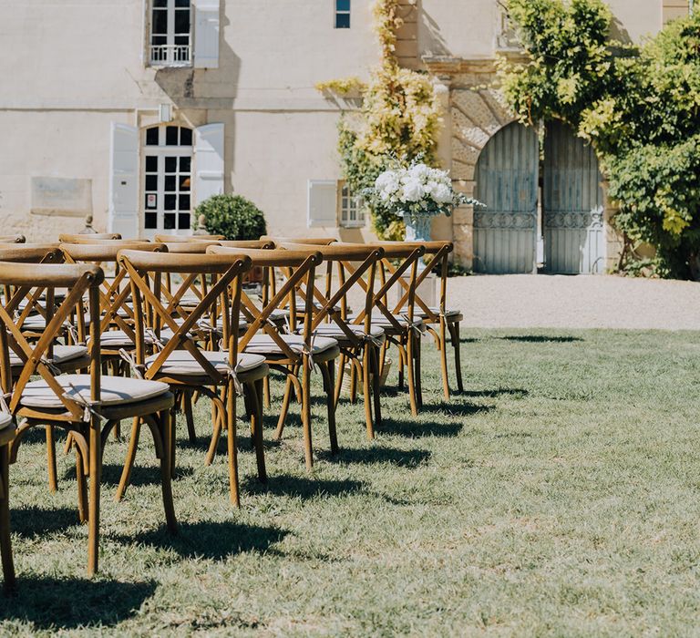 outdoor wedding ceremony at Château de Malliac with wooden chairs