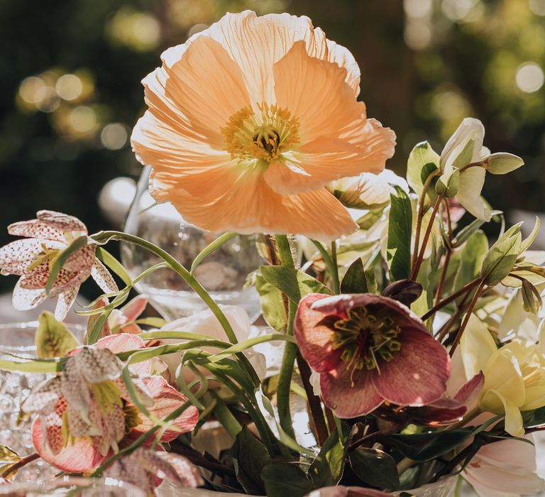 Blush toned poppy, peonies, foliage and other blush flower centrepiece on outdoor wedding tablescape at Euridge Manor 