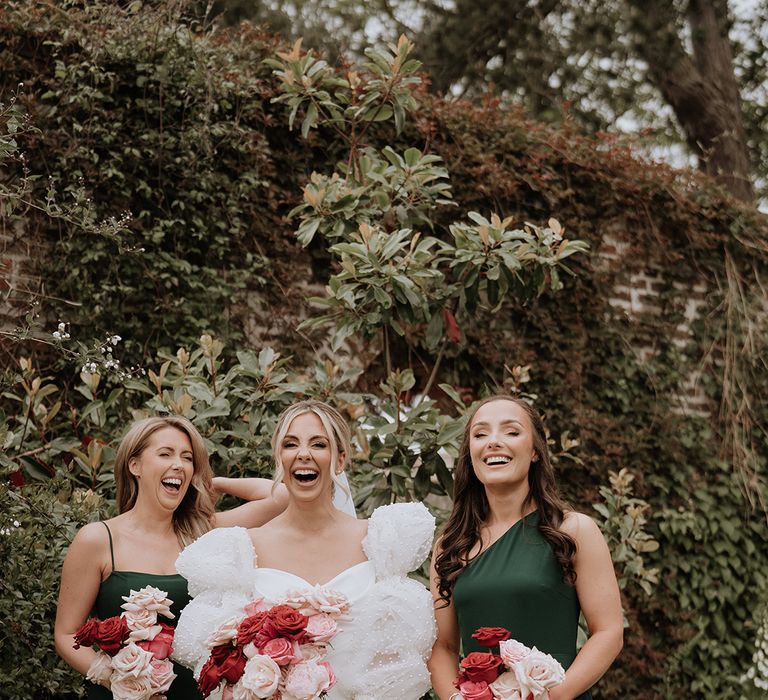 Bridesmaids in forest green bridesmaid dresses with bride at country house wedding 