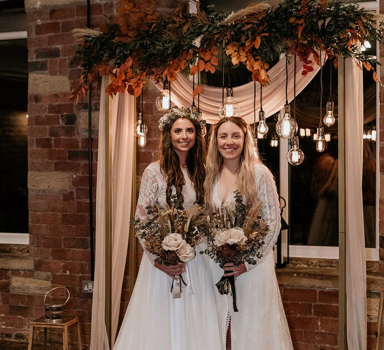 Light bulb festoon lighting decorating the altar for two brides at gay wedding