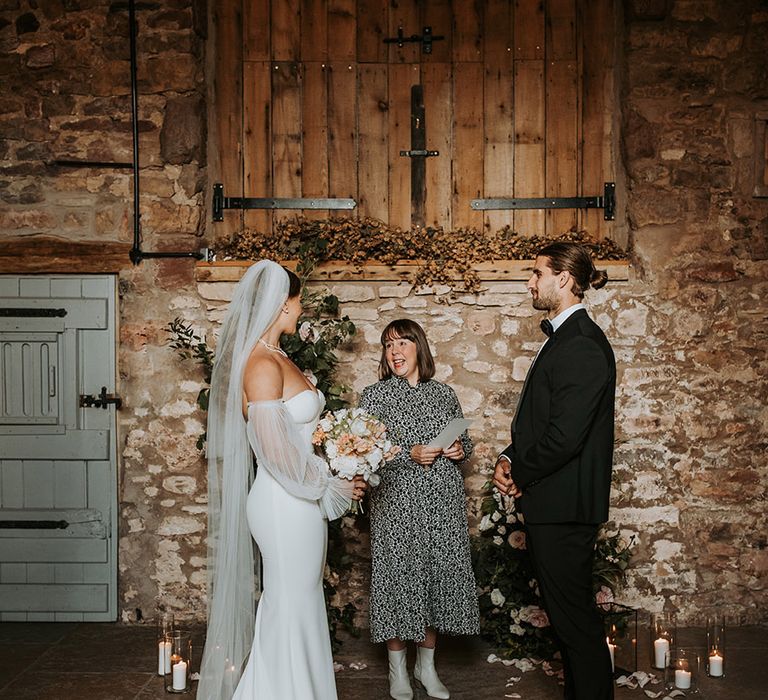 Eden Barn wedding with bride and groom standing for their ceremony 