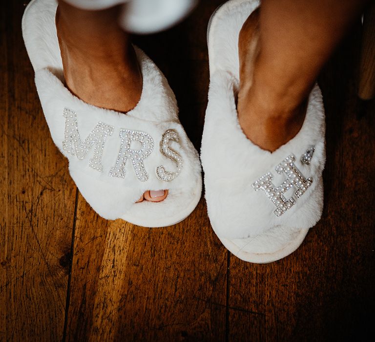 Bride wearing white fluffy slippers with embellished details 