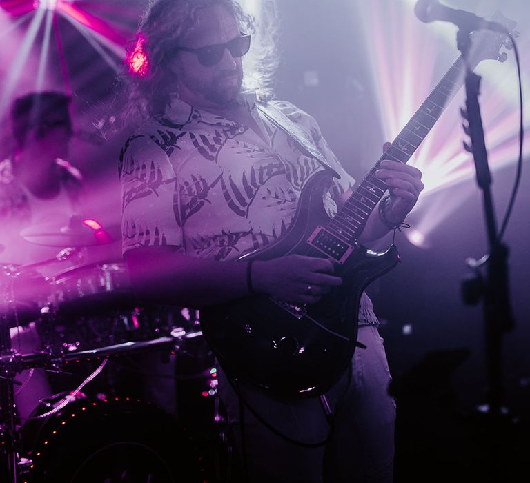 Guitarist in live band playing at wedding reception 