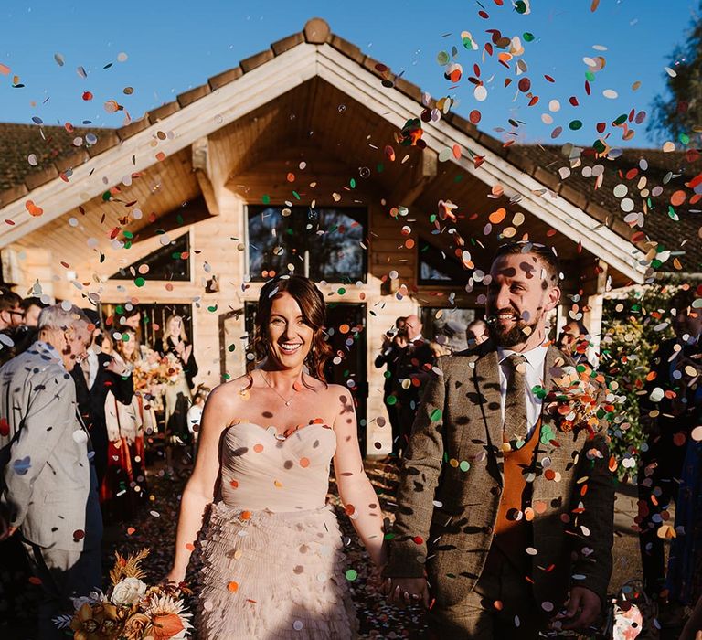 Green orange and white wedding confetti moment for the bride and groom to celebrate their wedding 