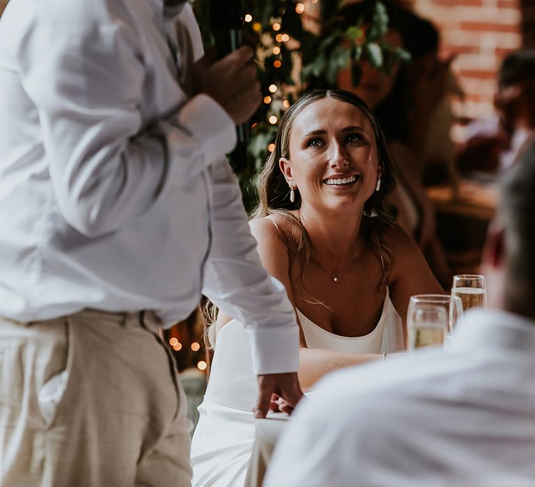  Bride smiles at the groom during the wedding speech he reads out 