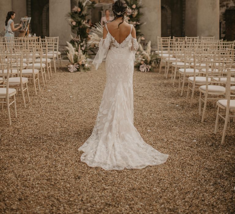 Bride walking down the aisle in cold shoulder wedding dress