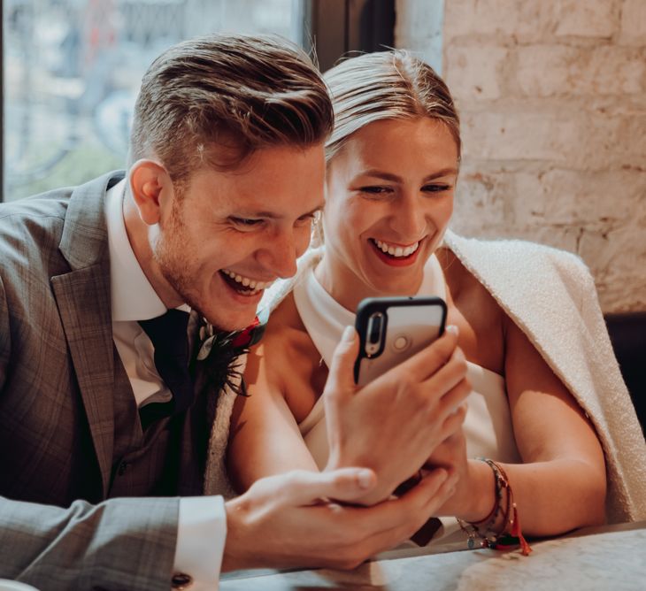 Bride and groom FaceTiming friends after their micro wedding 