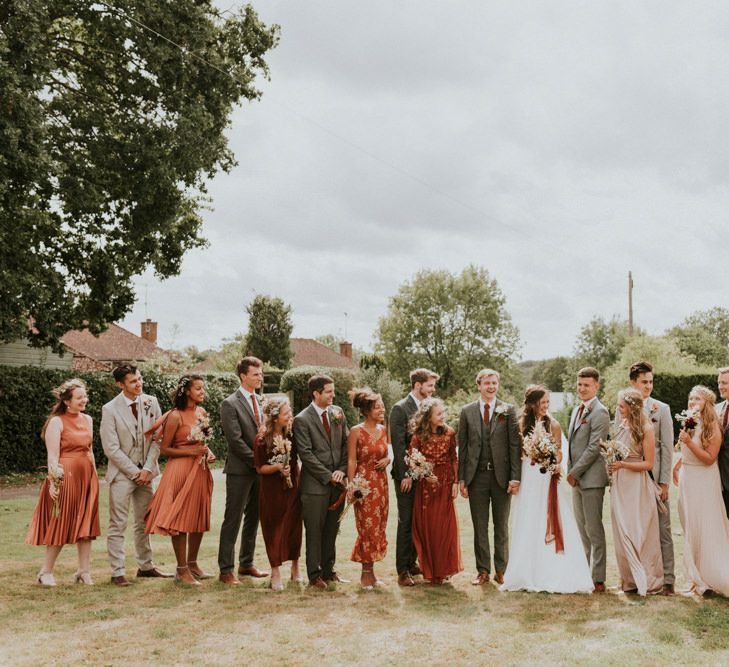 Wedding party portrait with bridesmaids in orange dresses 