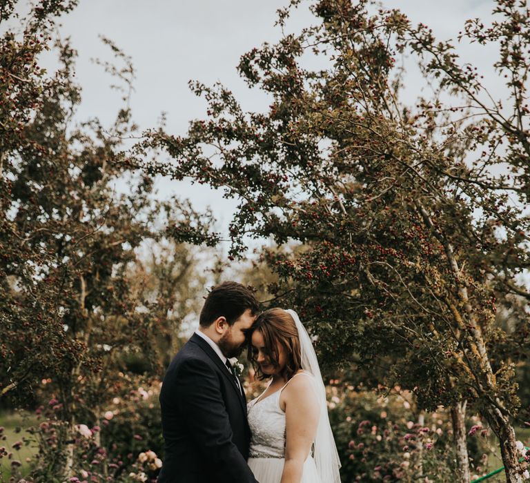 Bride and groom in garden with pink flowers