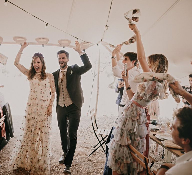 Bride and groom greeted by guests in their outdoor marquee