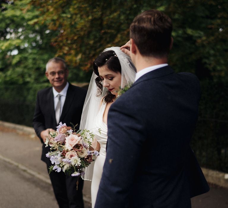 Groom helps bride remove confetti from hair