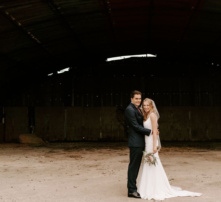 Bride and groom portrait on the grounds of Clock Barn wedding venue in Hampshire 