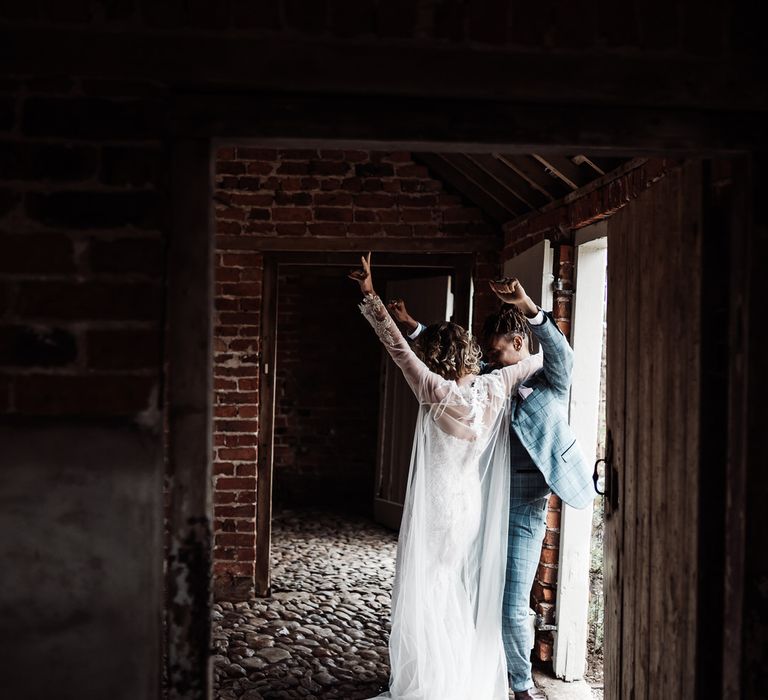 The bride and groom dance inside an exposed brick, cobble stone barn