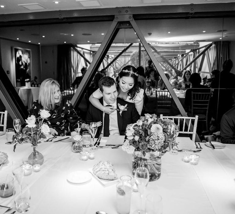 Bride in a Tilly Thomas Lux crown embracing her groom during their micro wedding reception 