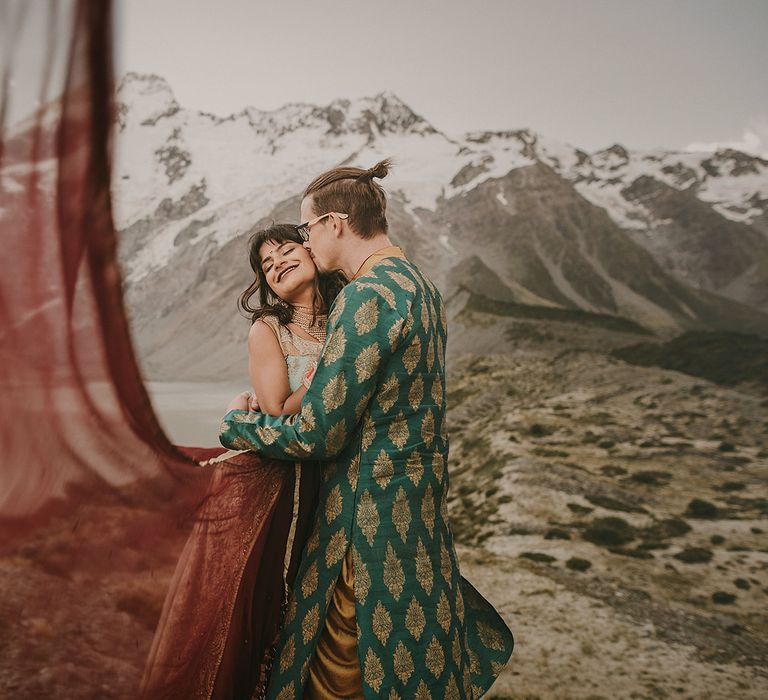 The bride's veil flows in the wind of the New Zealand mountains