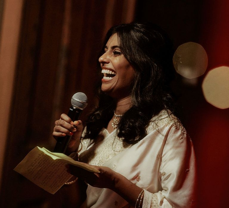 Smiley Sri Lankan bride in a white sari giving her wedding speech 