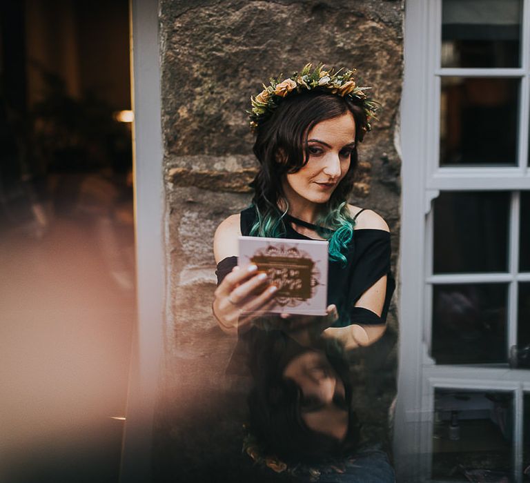 Dark haired bride checks makeup before wedding ceremony