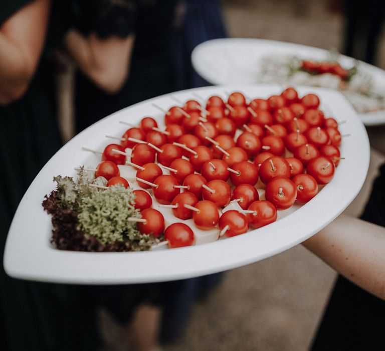 White oval shaped platter of tomatoes and cheese at rural German wedding