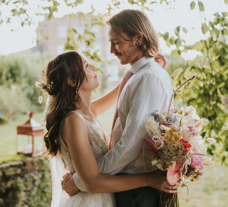 Bride & groom embrace outdoors and stare lovingly into each others eyes