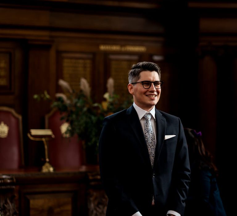 Groom in a navy suit with splatter pattern tie 