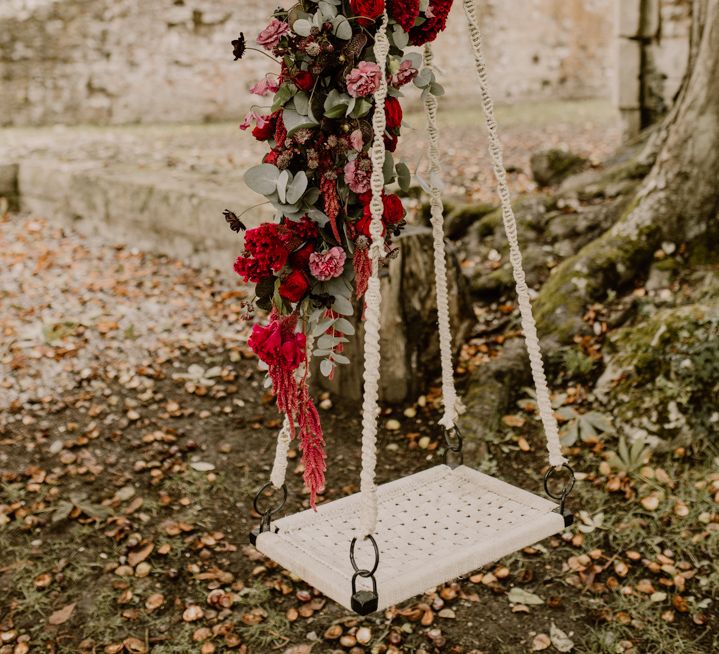 Wedding swing with red floral arrangement 