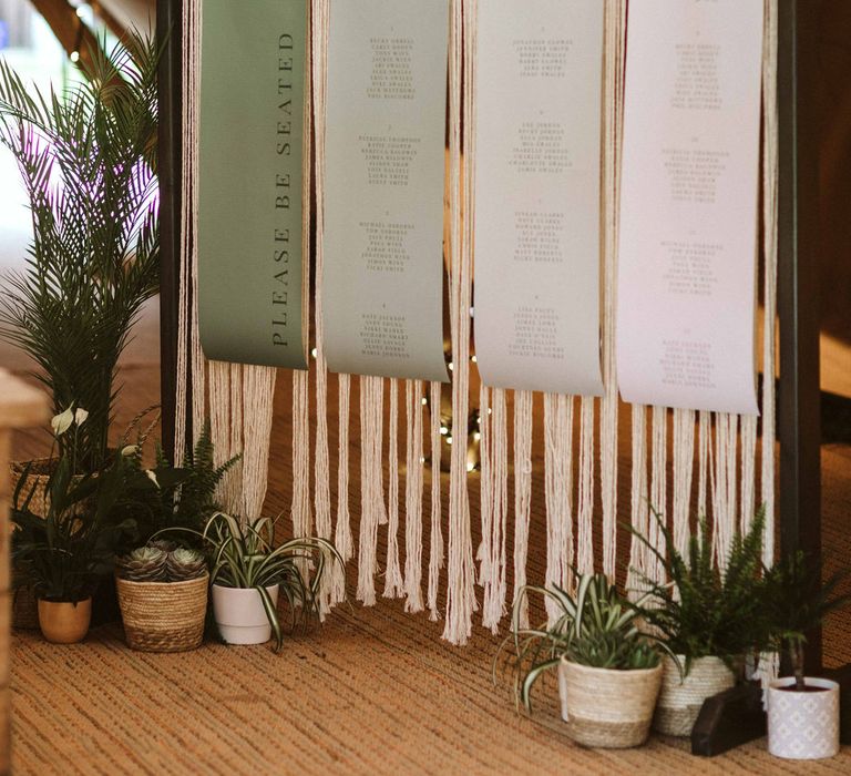 Wedding stationery on Macrame backdrop featuring different shades of green paper