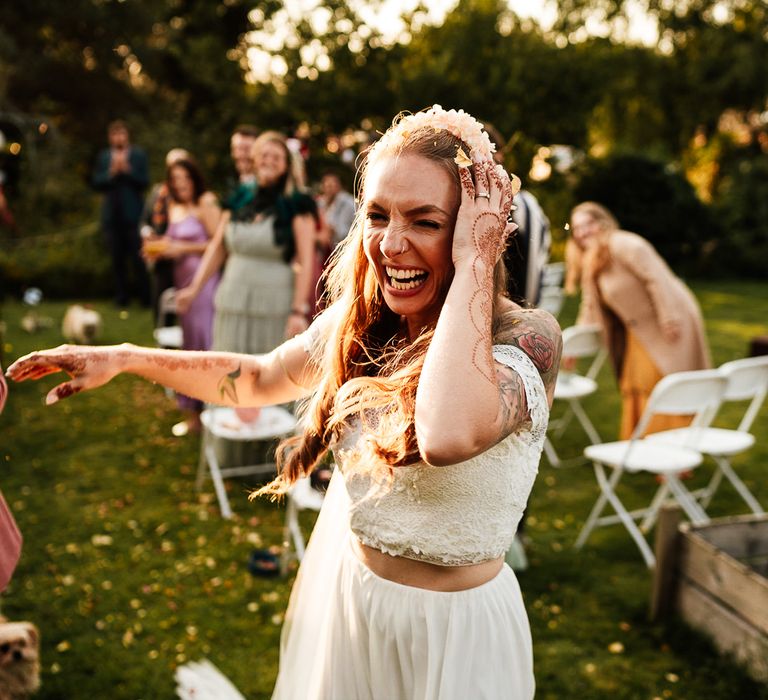 Bride laughs outdoors as she wears bridal two piece