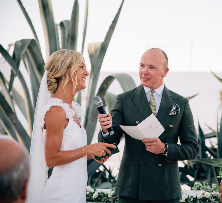 The bride and groom standing at the altar reciting their vows