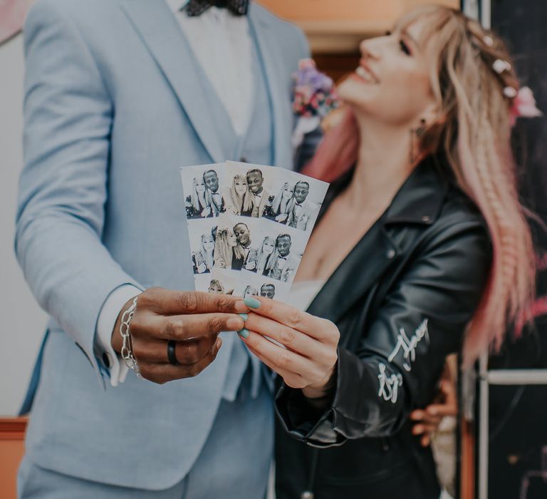 Bride and groom holding up pictures from their Photo Booth 