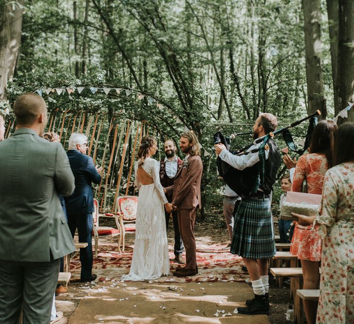 Outdoor woodland wedding ceremony with streamers, rugs and bunting wedding decor 