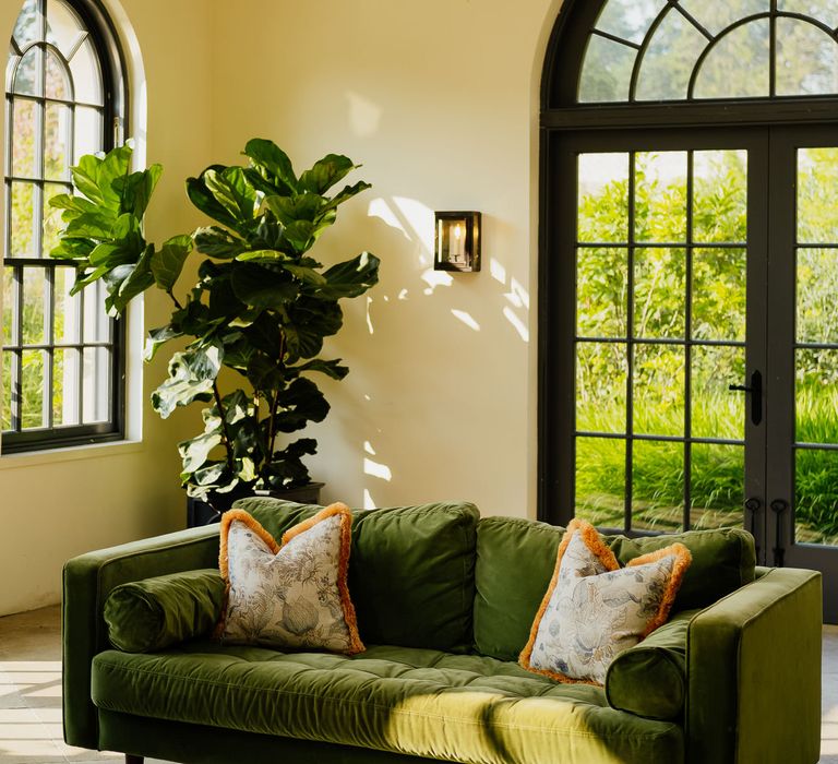 Dark green velvet sofa and giant house plant at fiesta theme wedding 