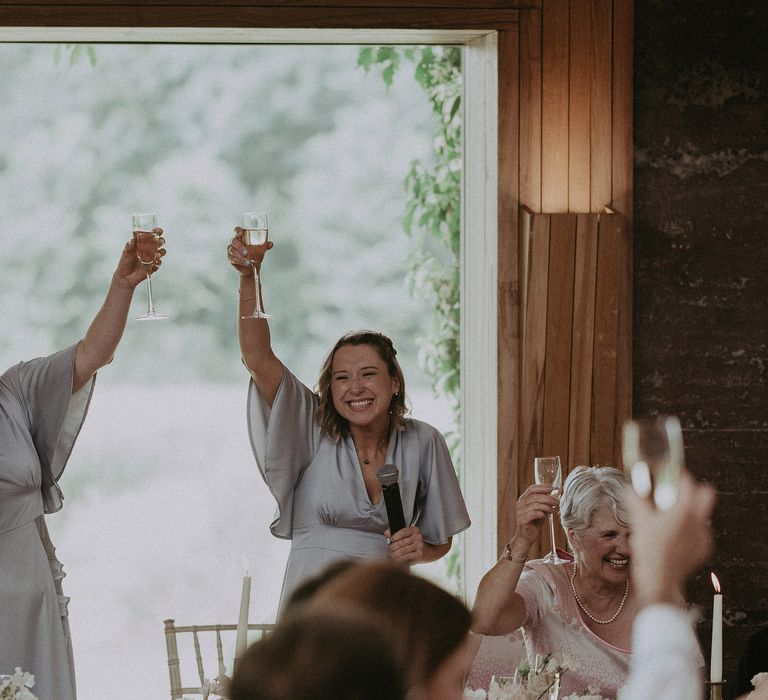 Bridesmaids raise their glasses on wedding day for bride & groom