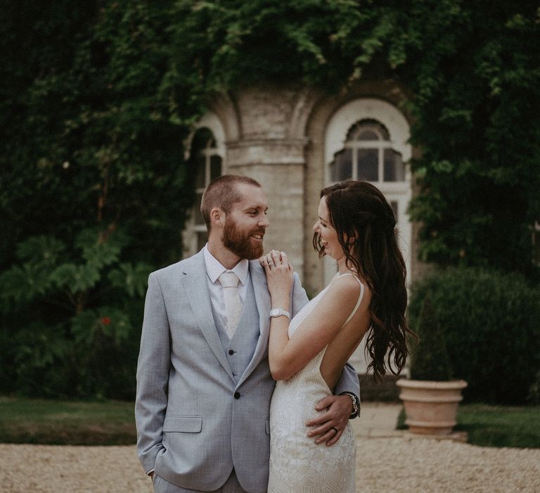 Groom in blue wedding suit with bride in Made With Love wedding dress