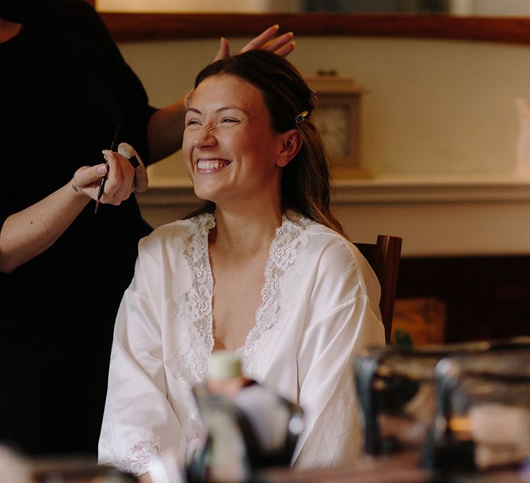 Bride gets her makeup done before wedding