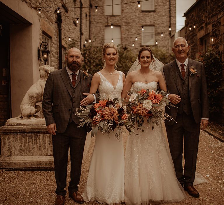 Brides stand with their fathers on the day of their wedding