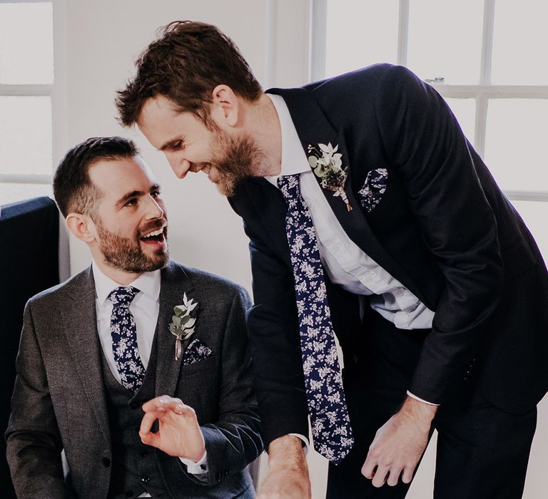 Groom sits with his groomsman and talks on wedding day