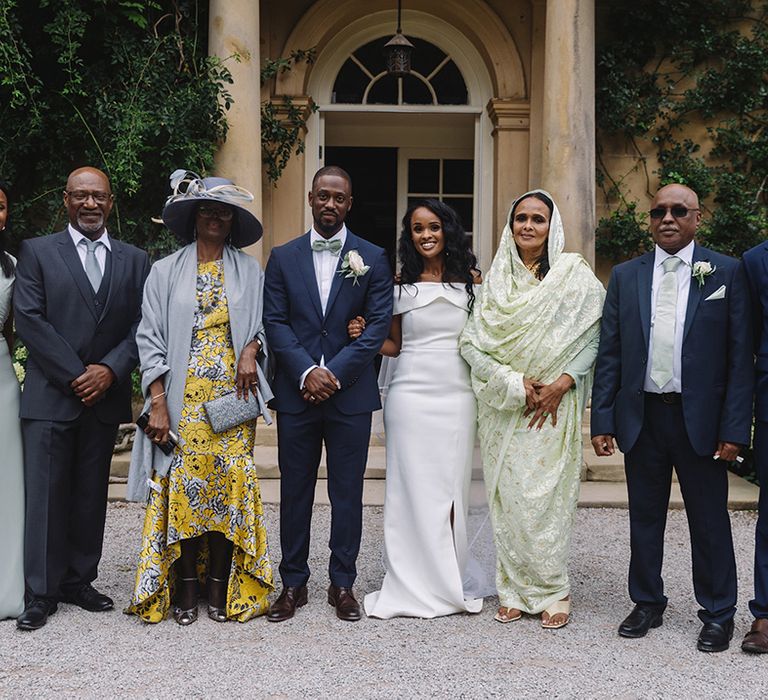 Bride and groom's family stand altogether with mint green details