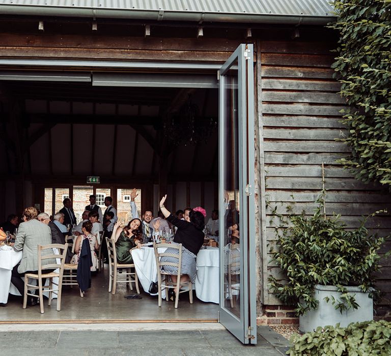 Wedding guests are seated inside the Southend Barns wedding venue 