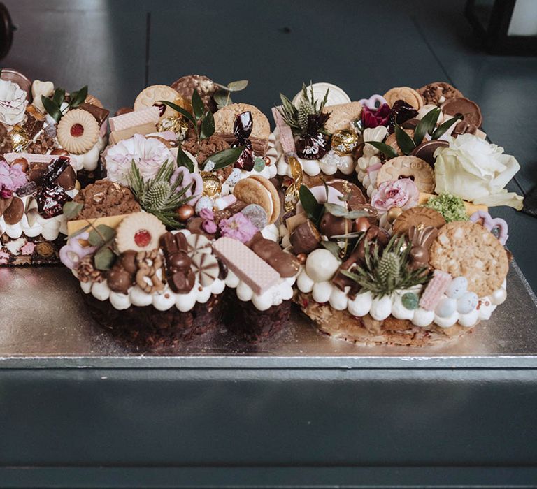 Dessert and sweet treats grazing table with wafers, rocky road, Jammie dodgers and much more with thistle and rose decoration