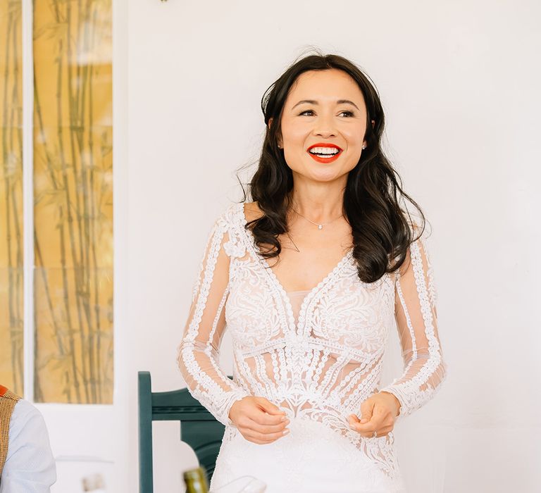 Bride in long sleeve illusion lace wedding dress stands and gives a speech at the wedding breakfast 