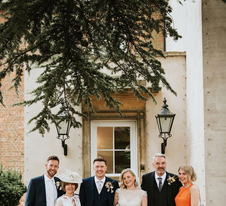 Bride & groom stand with family outdoors on their wedding day at Aswarby Rectory 