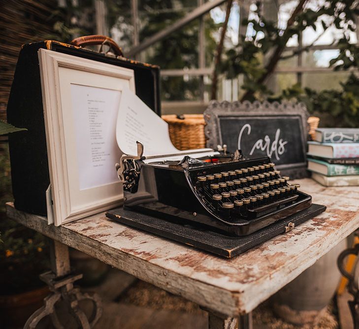 Vintage typewriter on wooden table surrounded by books and chalkboard 