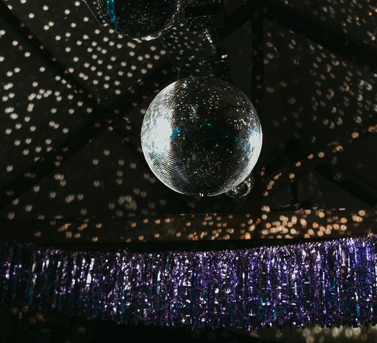 Colourful purple streamer decoration with a disco ball wedding decoration 