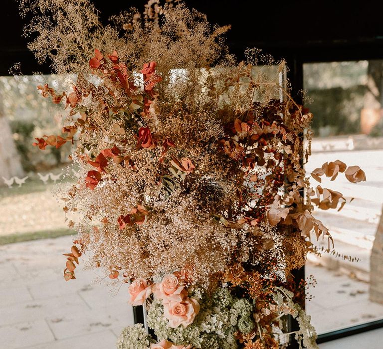 Rust and lavender wedding flower column with neutral colour palette and pops of colour 