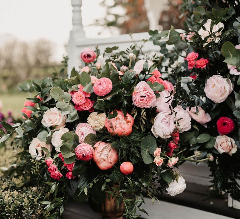 Pink wedding flowers decorating the outside for the outdoor ceremony at The Old Kent Barn