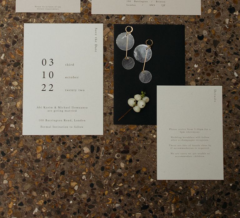 Minimalistic white wedding stationery with black lettering, snowberries and opaque circular drop earrings