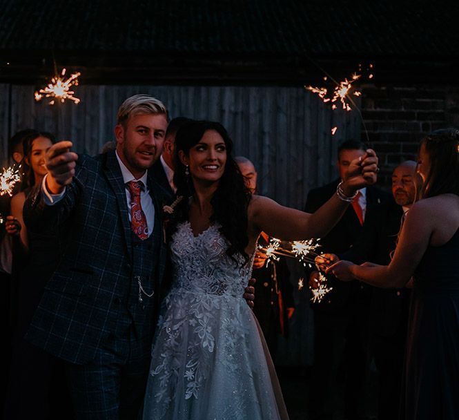 The bride and groom end their barn wedding in a traditional way with a sparkler send off 