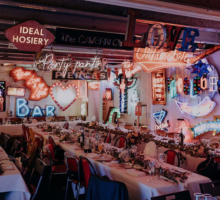 Reception room of Gods Own Junkyard; neutral, rustic tablescapes with foliage runners and rose and peony centrepieces 